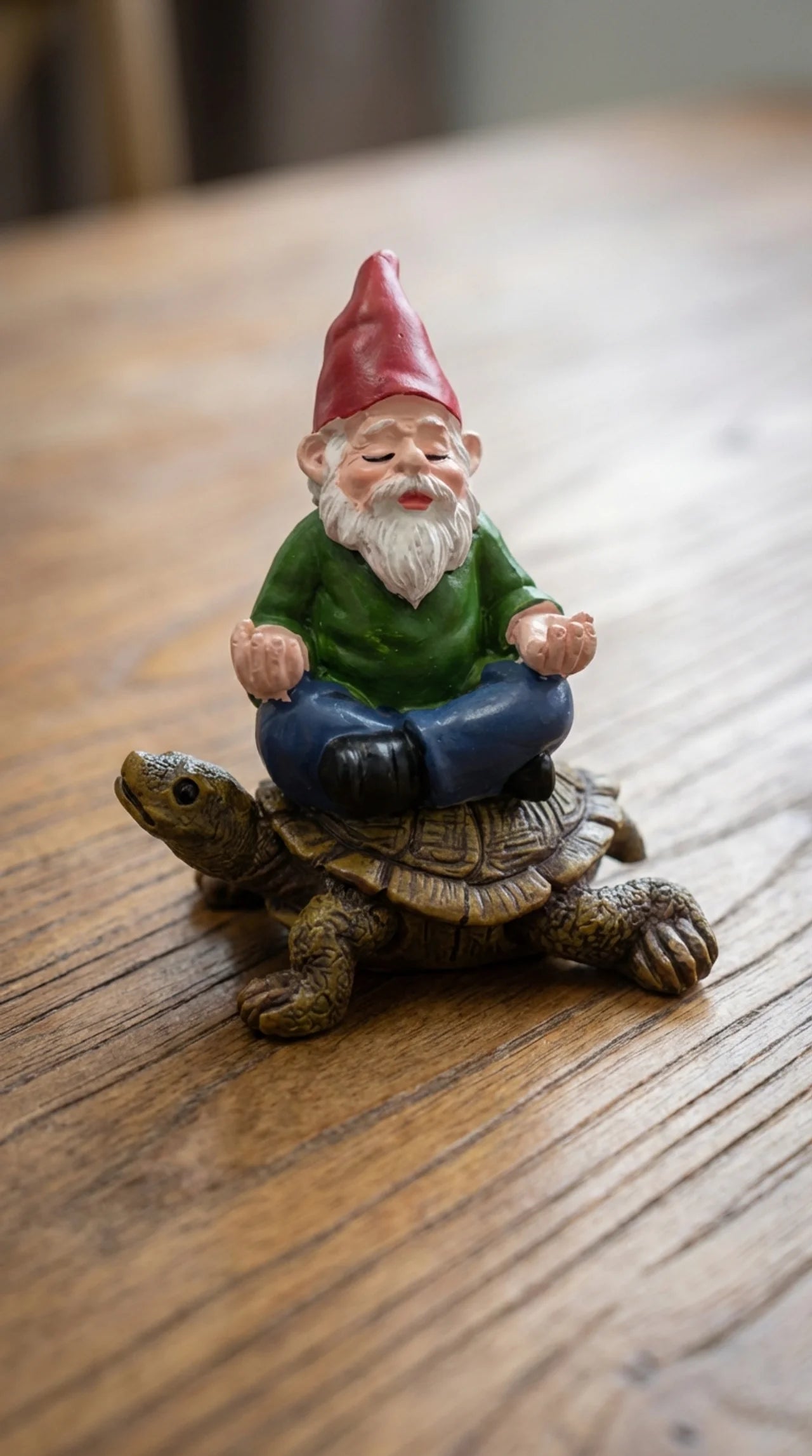 Close-up of Gnorman ornament showing hand-painted gnome face, red pointed hat detail, and warm brown tortoiseshell texture beneath