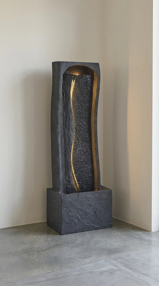 Tall faux slate waterfall fountain in dark charcoal polyresin, curved panel design with arched crown, 38.58 inches tall, outdoor patio setting with LED lights illuminated