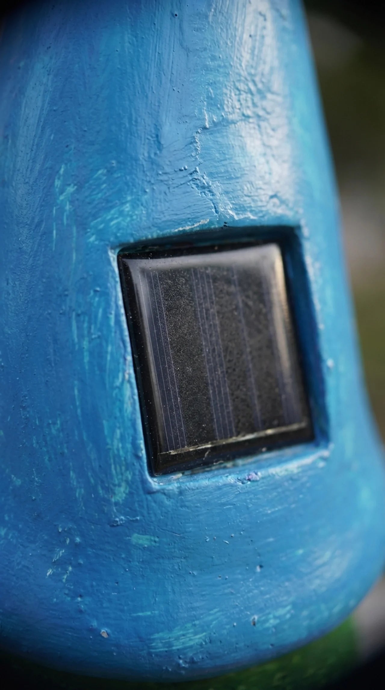 Blue gnome hat with a solar panel on a blurred background