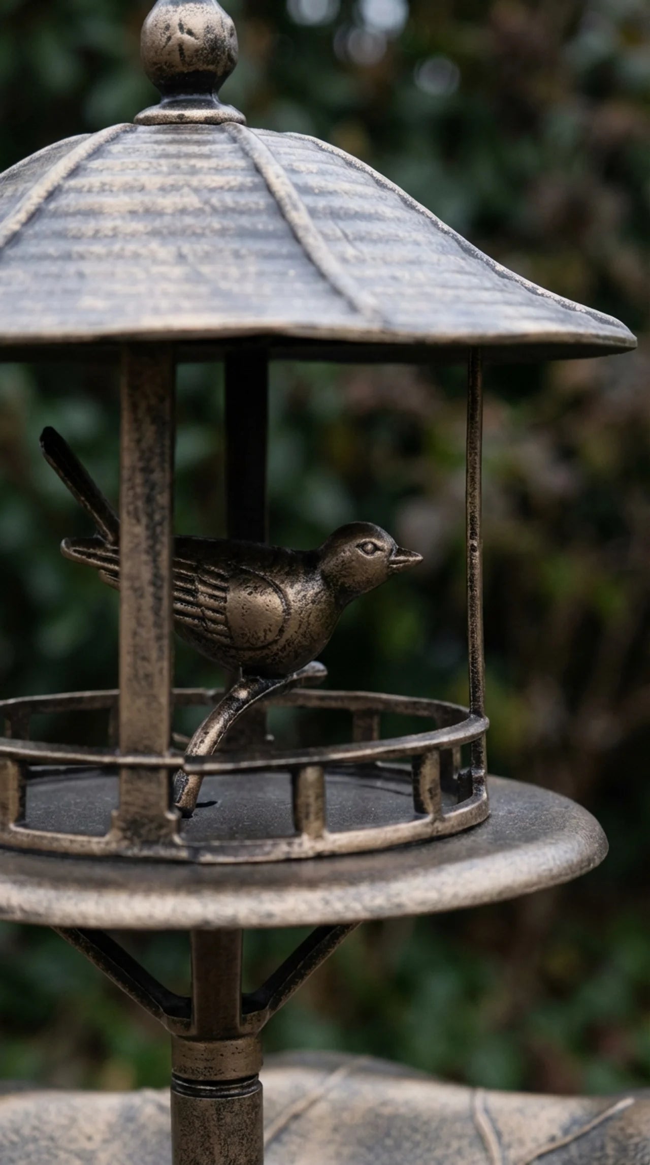 Close-up of aged bronze effect finish bird detaildecorative garden bird bath stand