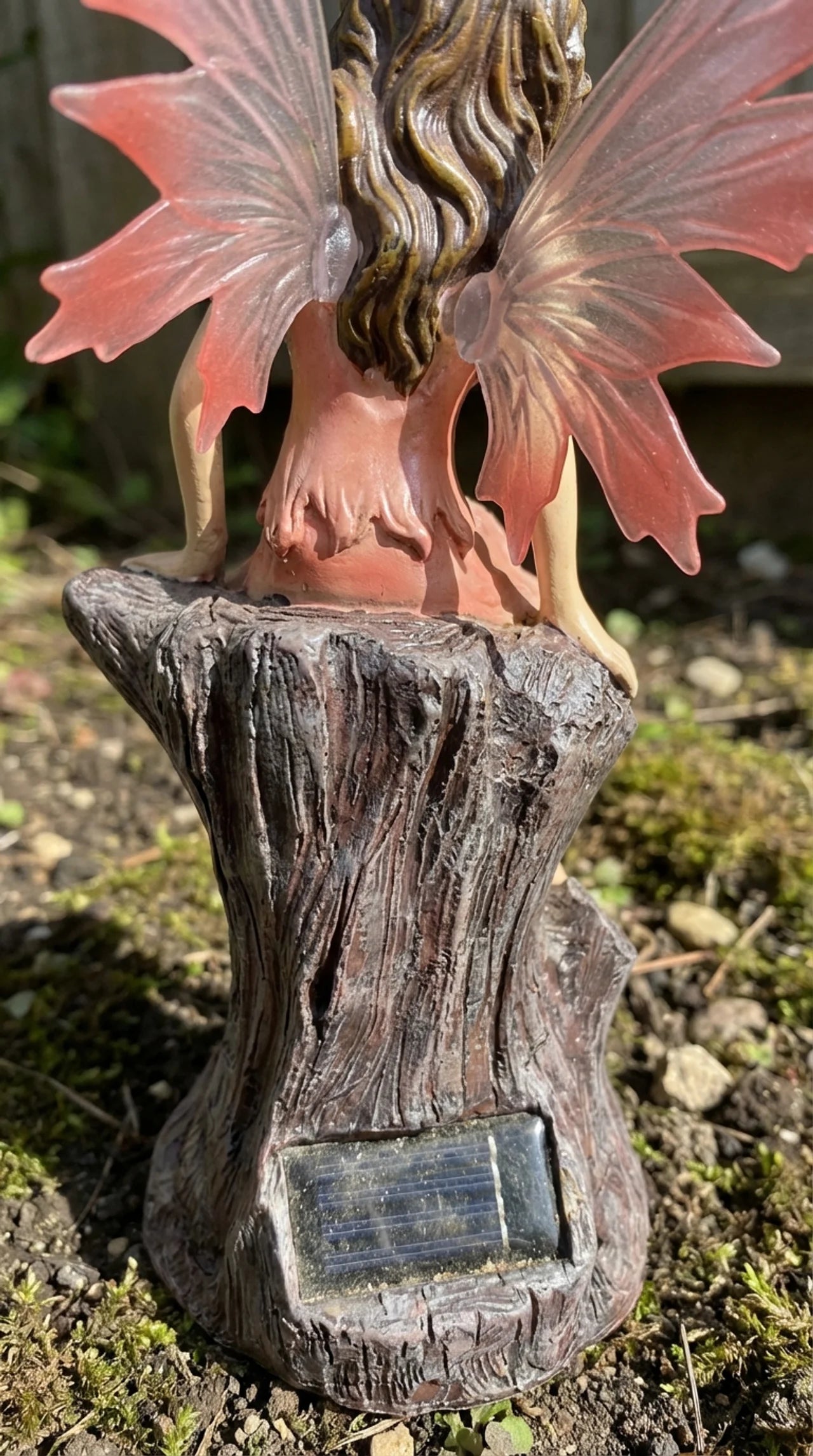 Decorative garden fairy statue with a solar panel on a natural base