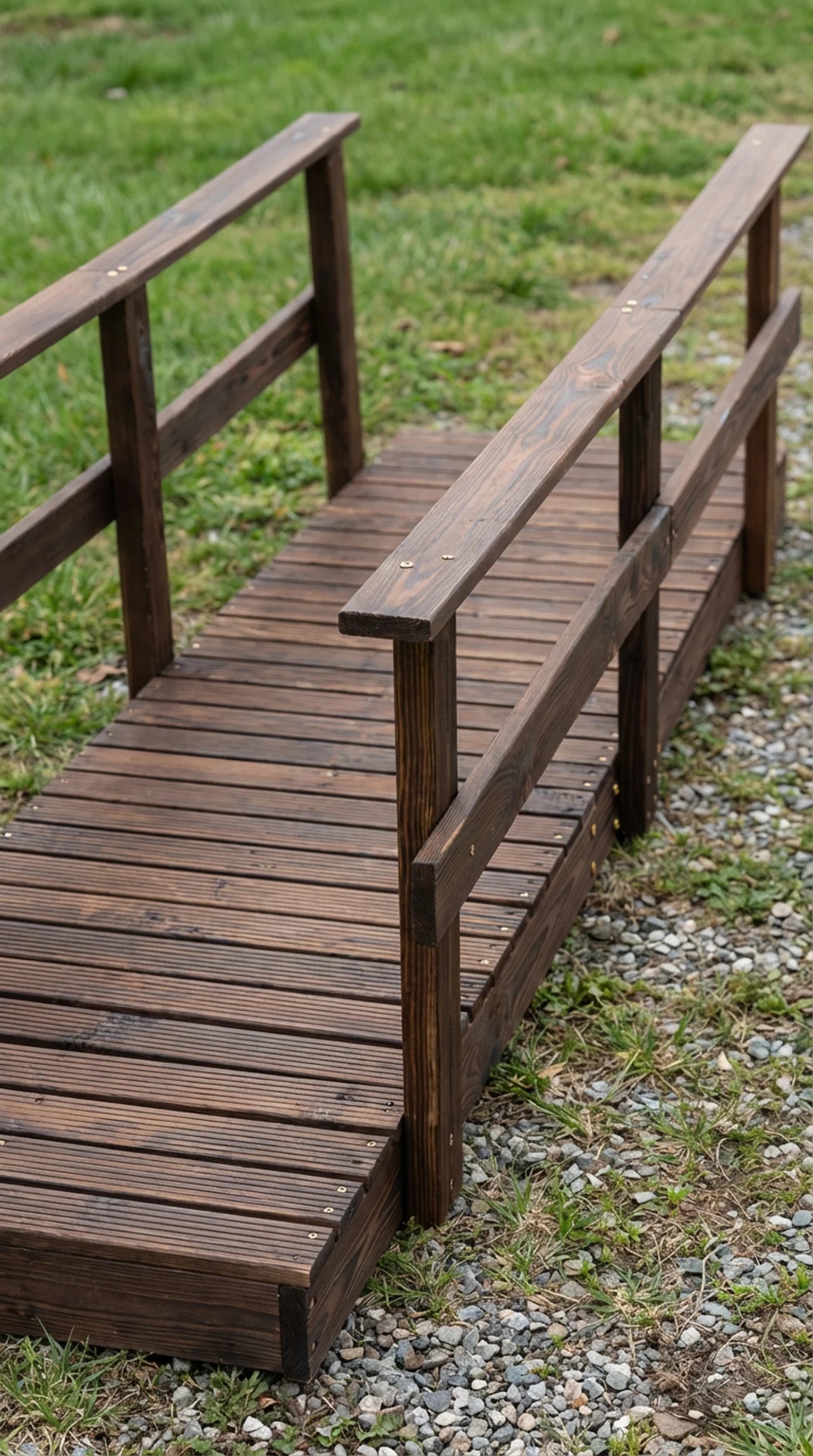 Close-up of stained pine deck boards and double handrail detail on wooden garden footbridge