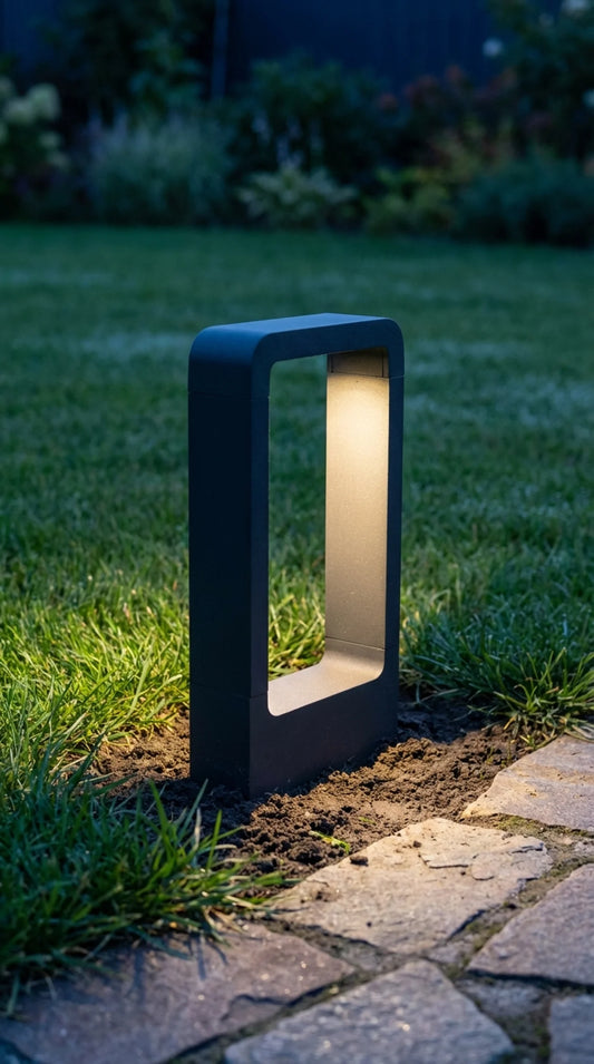 Wired LED garden bollard light in matte black aluminium, Form and Foliage collection, outdoor pathway setting at dusk