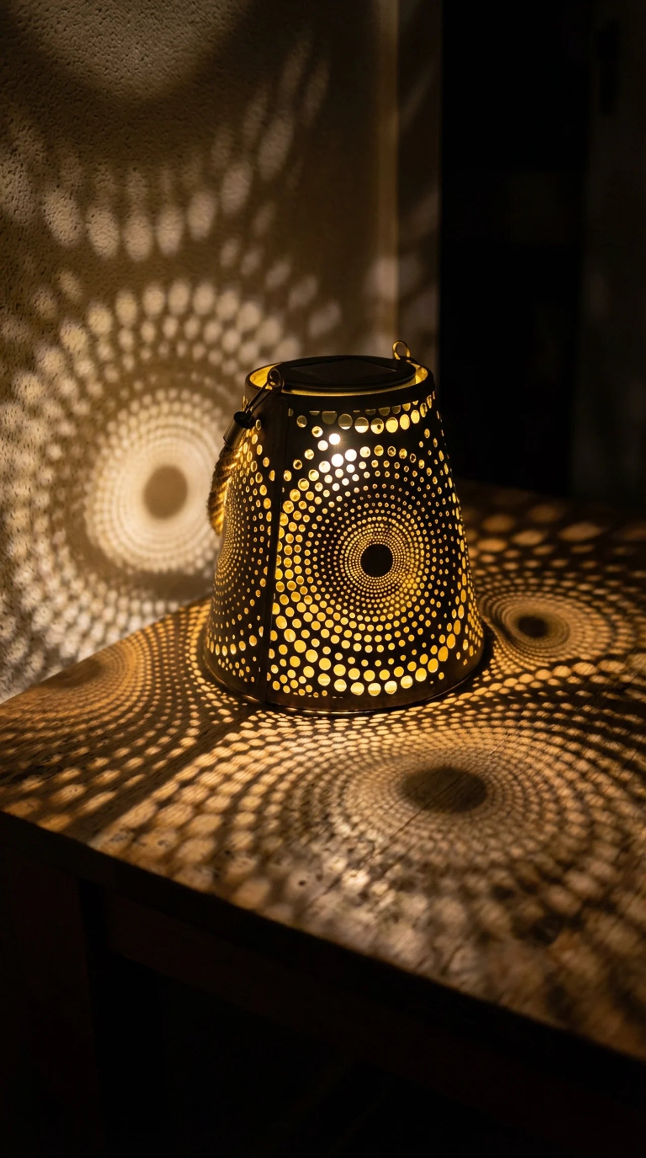Decorative lantern casting circular patterns on a dark surface