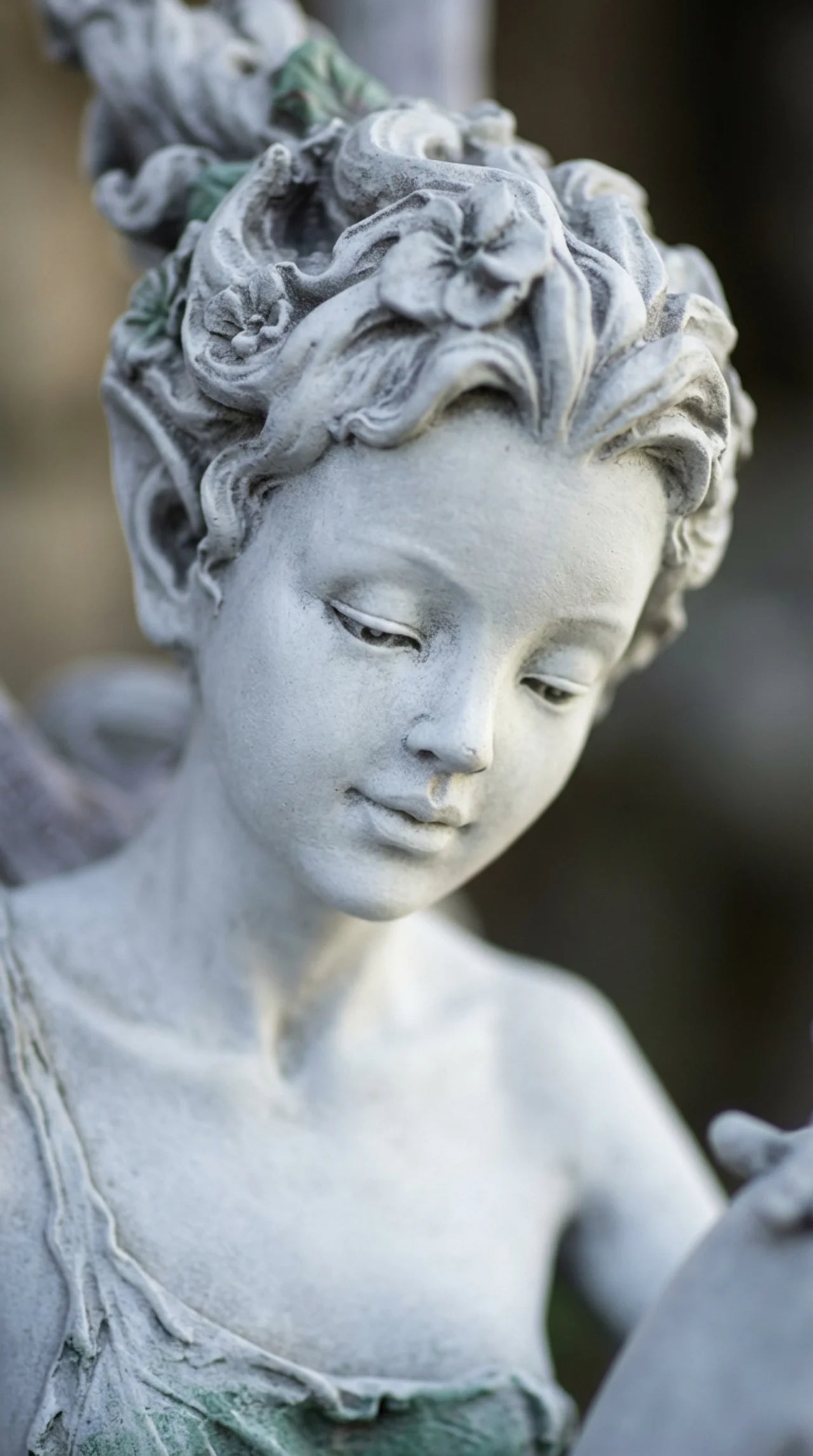 Close-up of fairy face detail on seated resin fairy garden statue in stone-effect grey finish